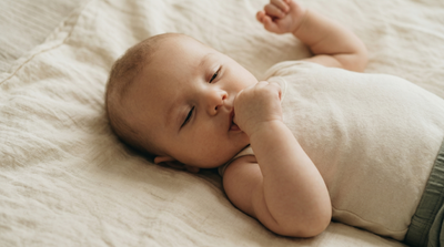 Baby calmly sucking on thumb after feeding