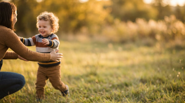 23 month old toddler running across the grass toward a parent