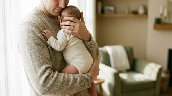 Father holding his 17 week old baby against his chest, hand cradling the head