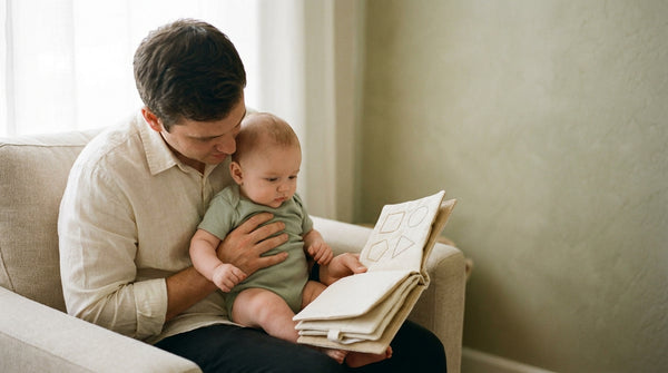 Father reading a cloth book with his 22 week old baby on his lap